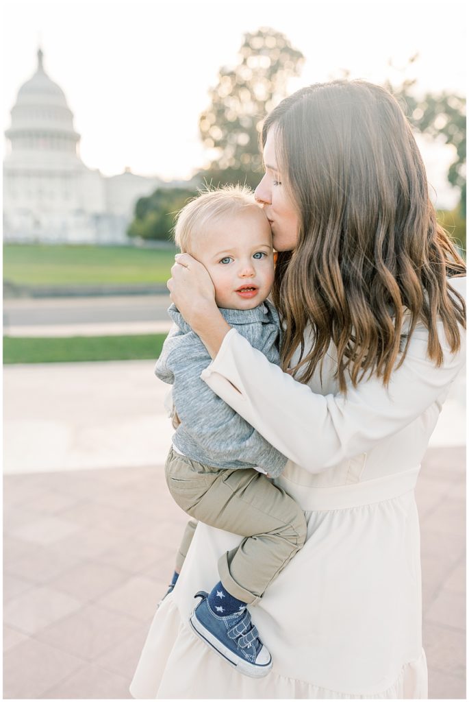 A Mother Kissing Her Toddler Son In Front Of The Us Capitol Building