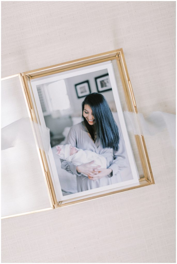 Photographs In A Gold, Glass Box Wrapped In Light Blue Ribbon