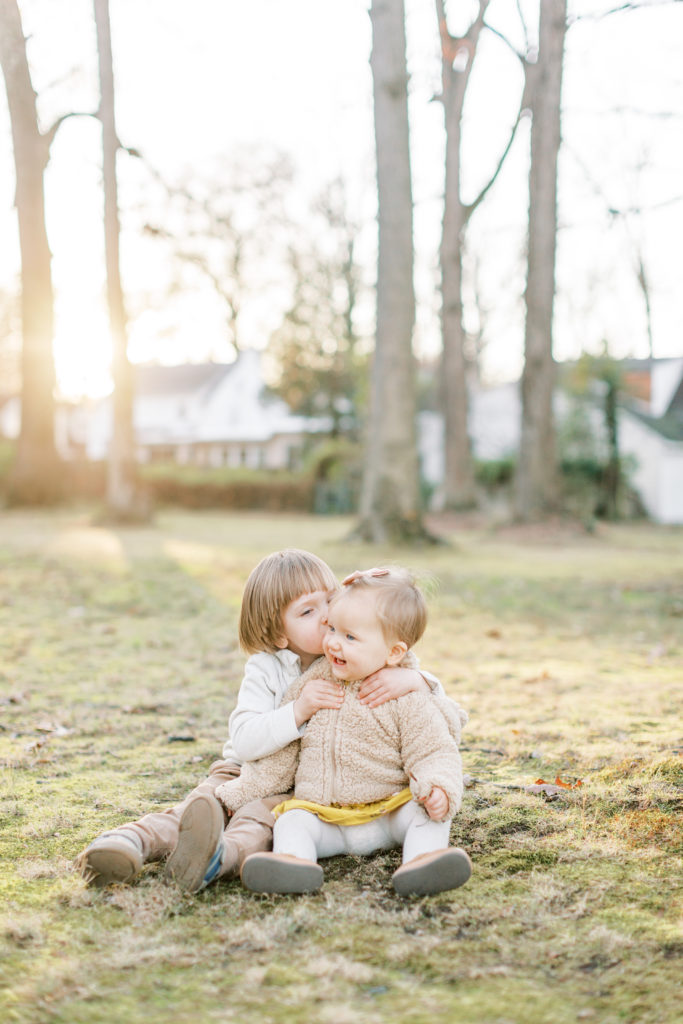 A Little Boy Kisses His Baby Sister In A Field At Sunset. 5 Steps To Take Better Phone Photos