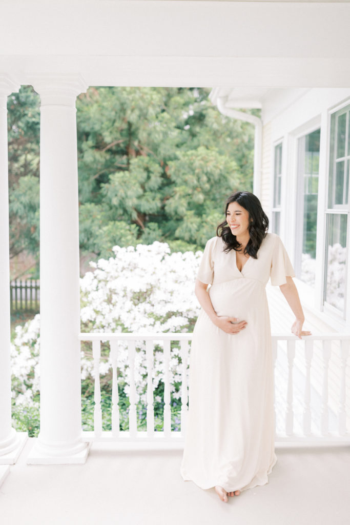 A Pregnant Mother Standing On A Porch During A Northern Virginia Maternity Session.