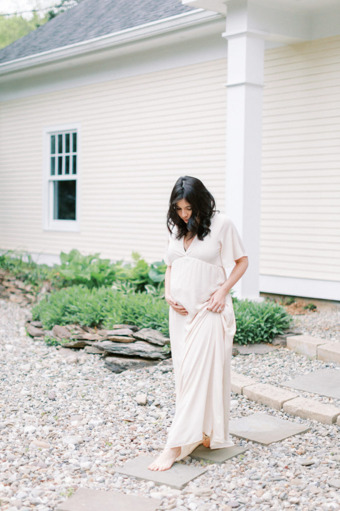 A Pregnant Woman Slowly Walking On Stones During A Dc Area Photo Shoot.