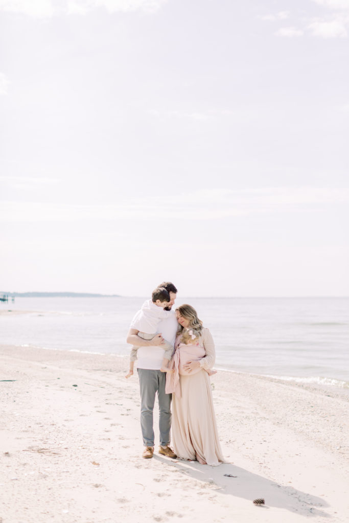 A Family Stands Close Together On A Beach.