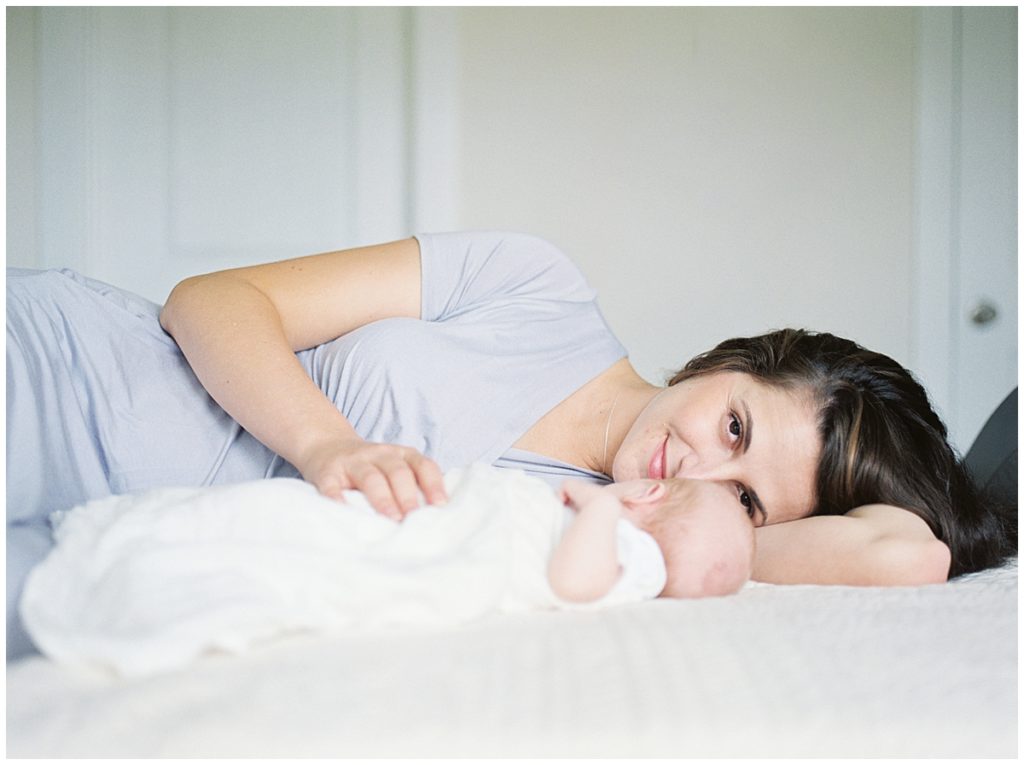 Mother Lays On Bed With Baby In Bethesda Baby Session.