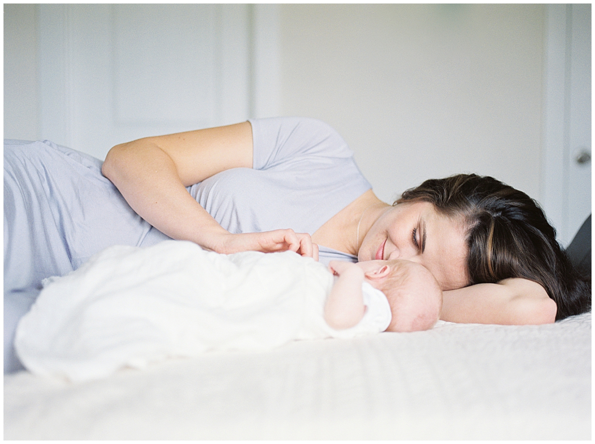 DMV Newborn Photographer - new mother lays on bed in Maryland newborn session