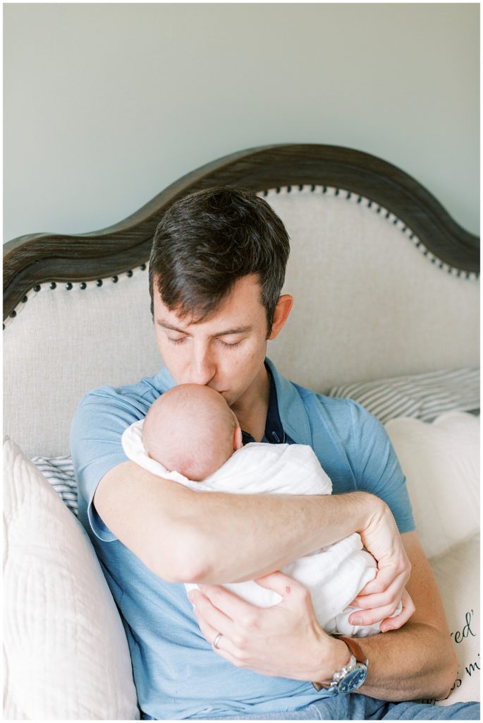 Father Kisses Baby During Potomac Baby Shoot.