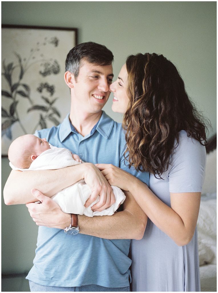 Mother And Father Nuzzle Together During Bethesda Newborn Photography Shoot.