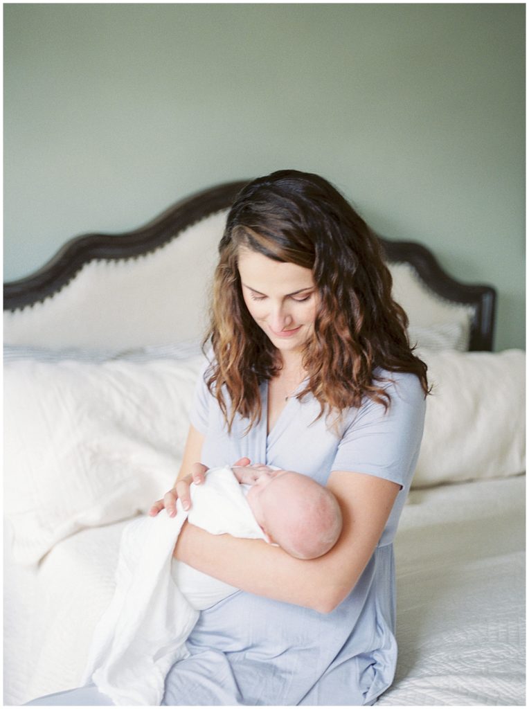 Mother Looks Down At Her Daughter During A Maryland Newborn Session.