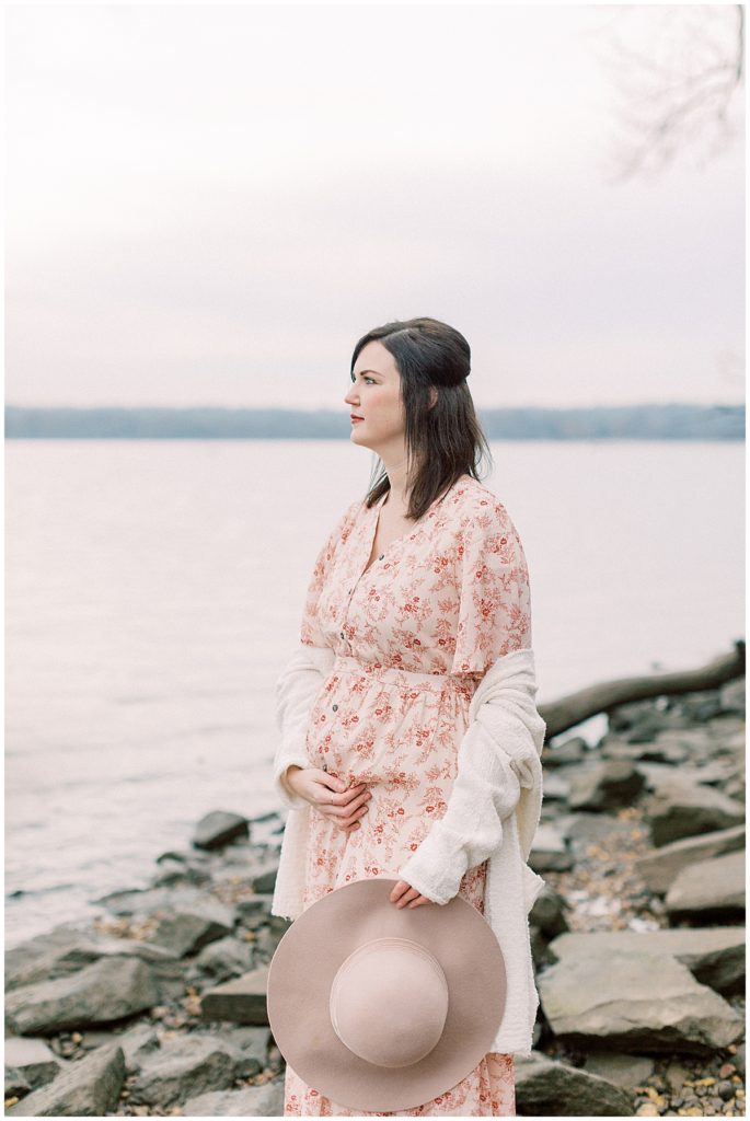 Mother Looks Out Into The Potomac River During Jones Point Park Maternity Session.