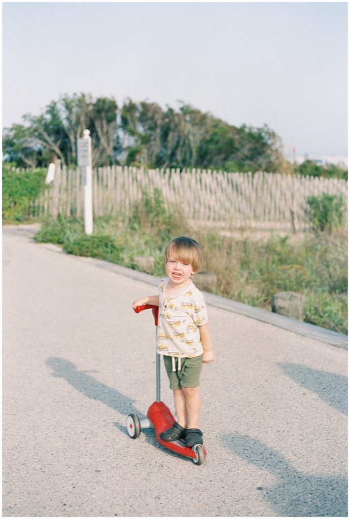 Little Boy On A Scooter On Boardwalk