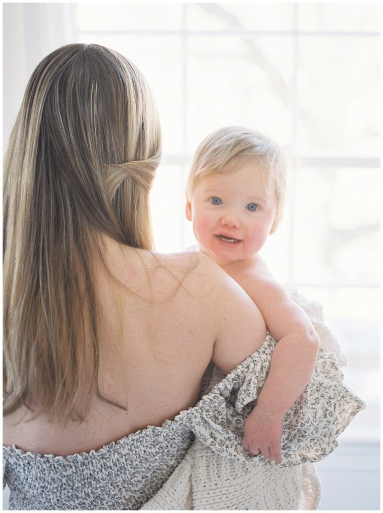 Mother Holds One Year Old Daughter At Window