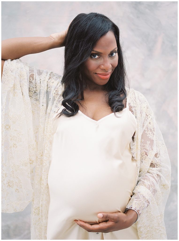 Gorgeous Pregnant Mother Standing With Hand Below Belly And Hand Behind Her Head