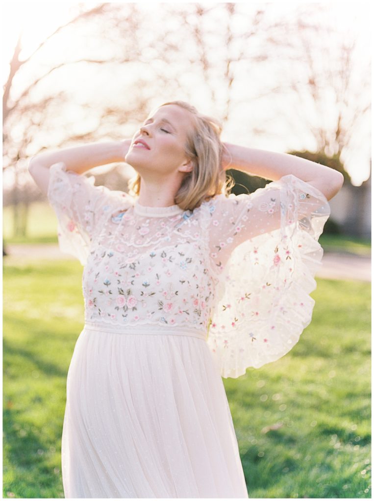 Northern Virginia Maternity Photographer | Pregnant Woman Stands With Arms Behind Her Head During Maternity Session