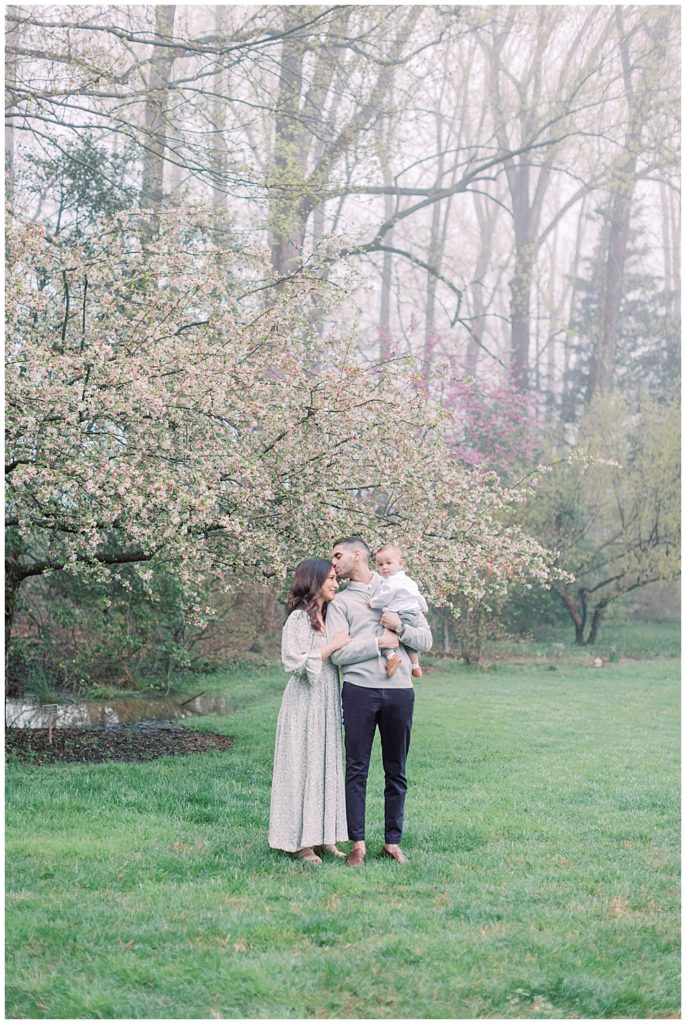 Father Kisses Mother's Head During Maryland Family Session At Brookside Gardens.