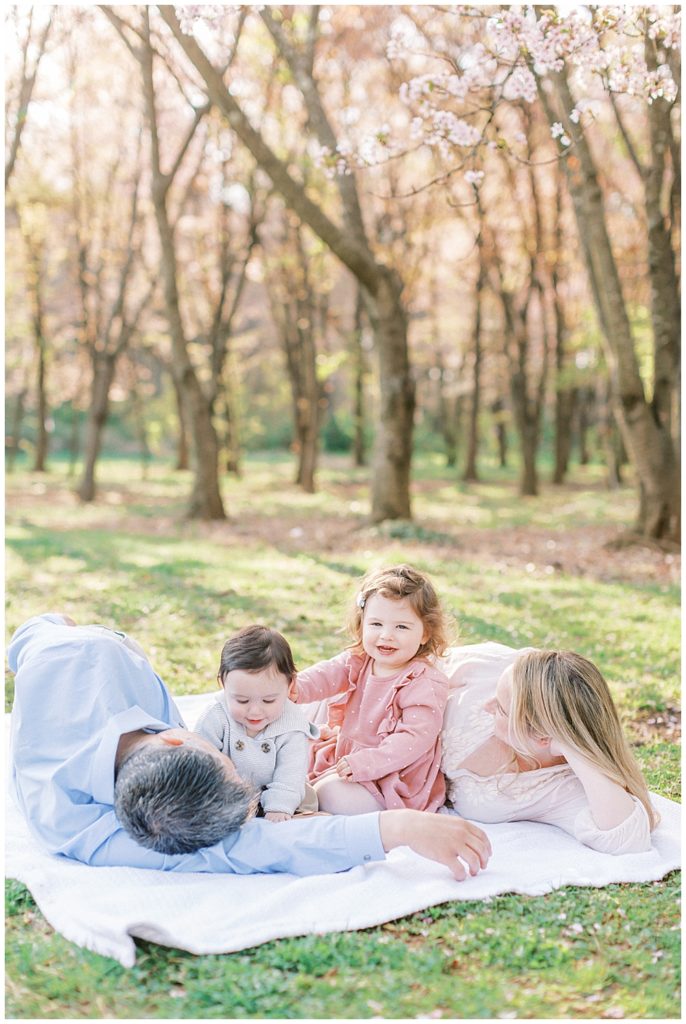 Family Lays Down On A Blanket At The National Arboretum