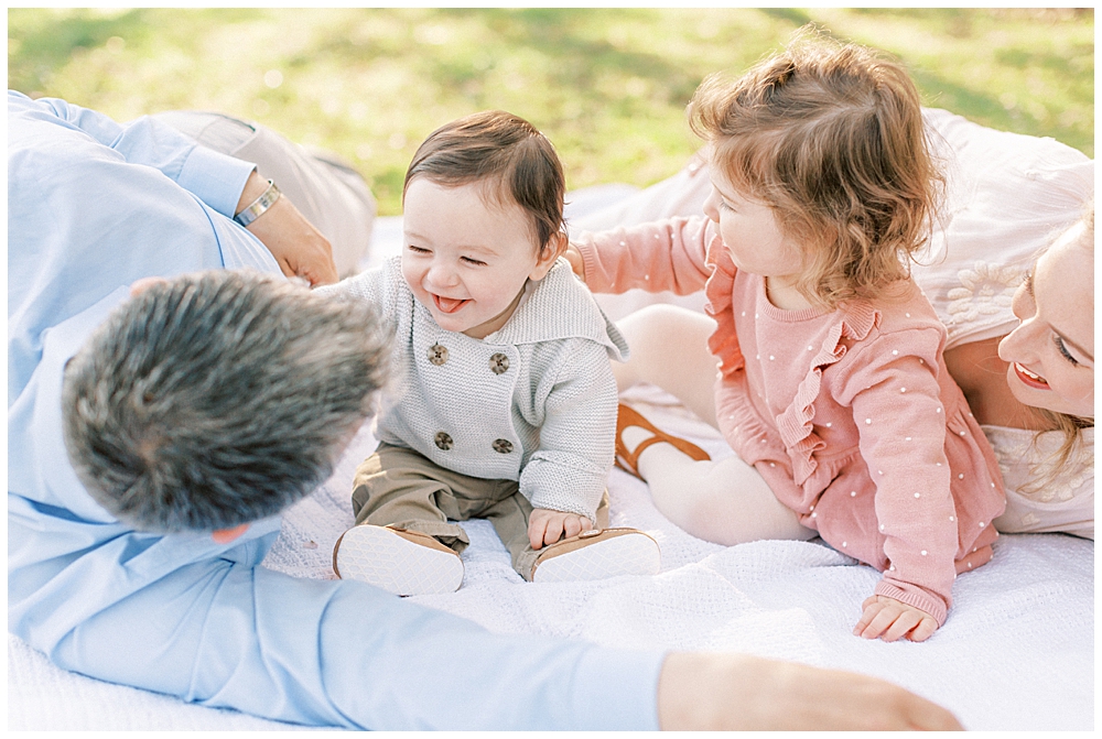 Family Lays Down On A Blanket During A Family Photo Session At The National Arboretum In Washington, Dc.