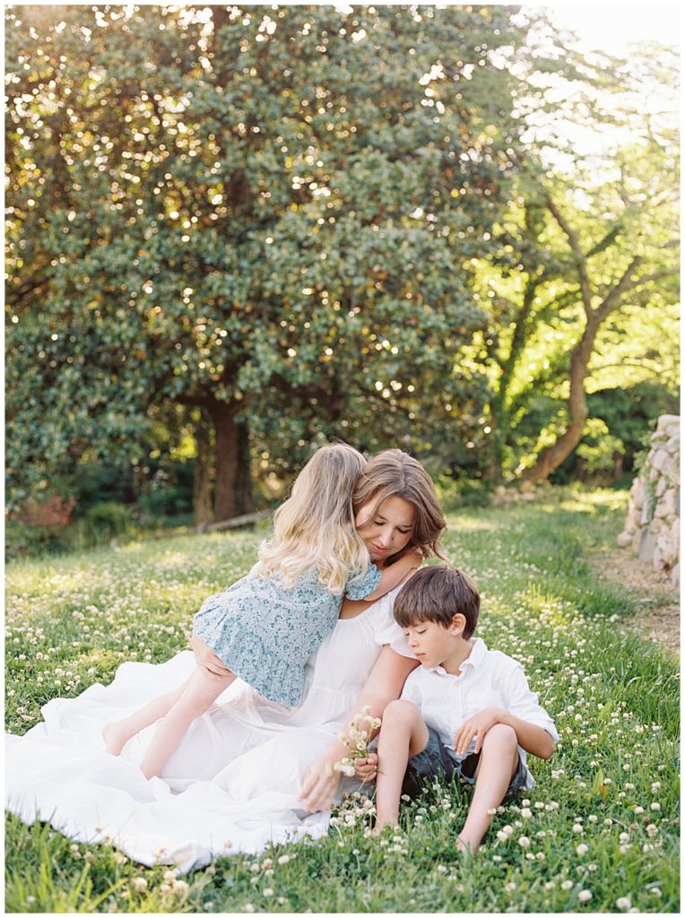 Little Girl Leans Over And Hugs Her Mother