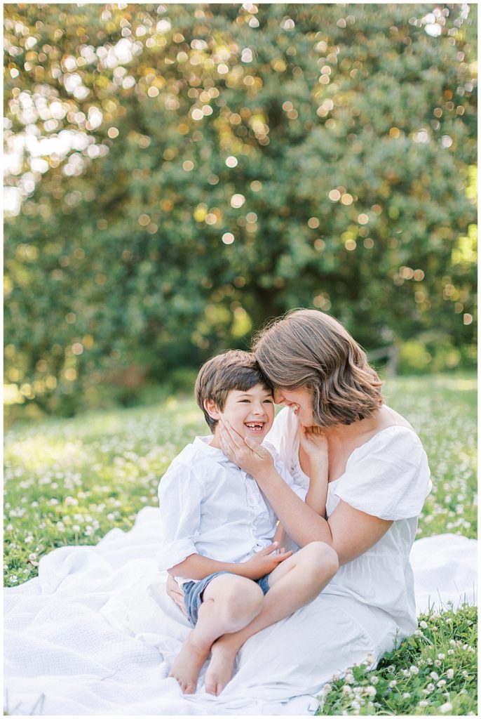 Little Boy Laughs While Sitting With His Mother