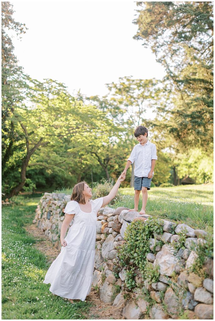 Mother And Son Walk Together Along A Fence