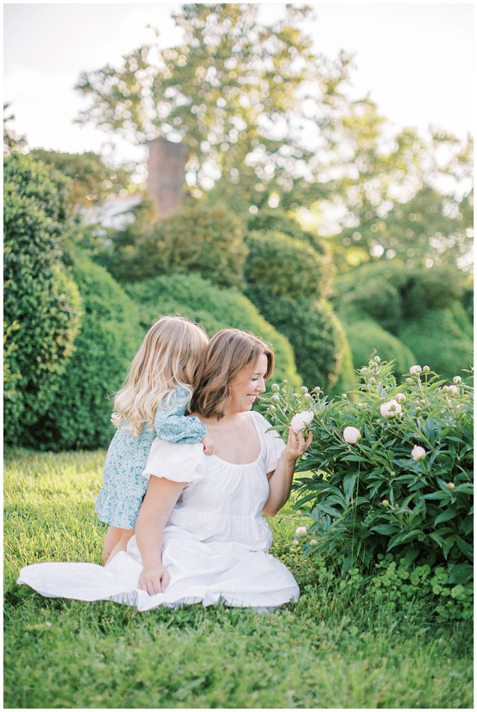 Daughter Gives Her Mother A Hug While The Mother Looks At Some Flowers