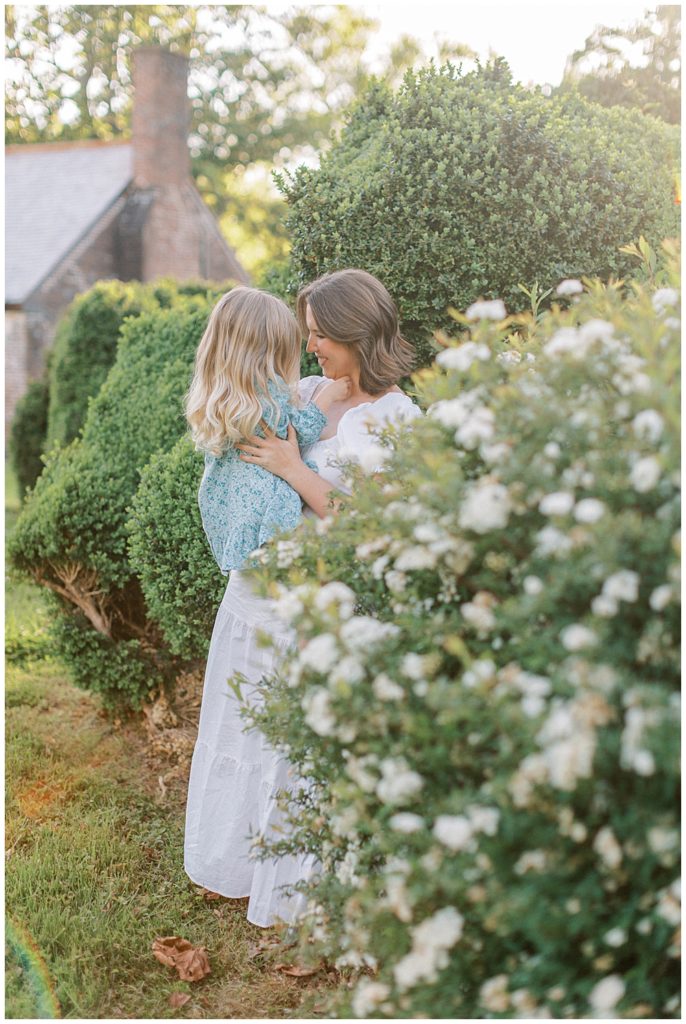 Mother Leans In To Her Young Daughter While Holding Her