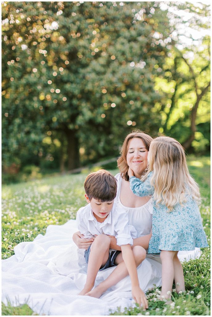 Little Girl Hugs Her Mother In A Field During Their Family Photo Session