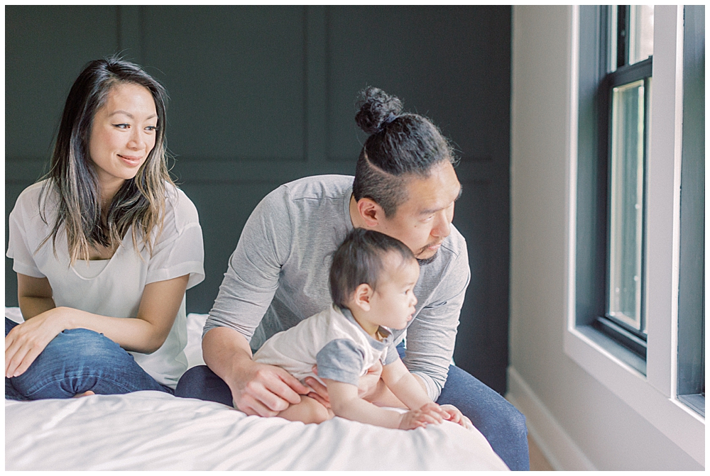 Parents Look Out The Window With Their Infant Son