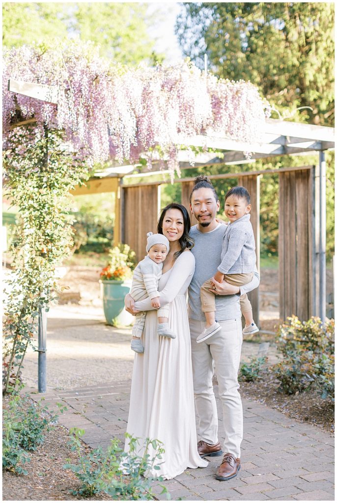 Washington, D.c. Family Photographer | Family Stands Near The Wisteria At Brookside Gardens In Silver Spring