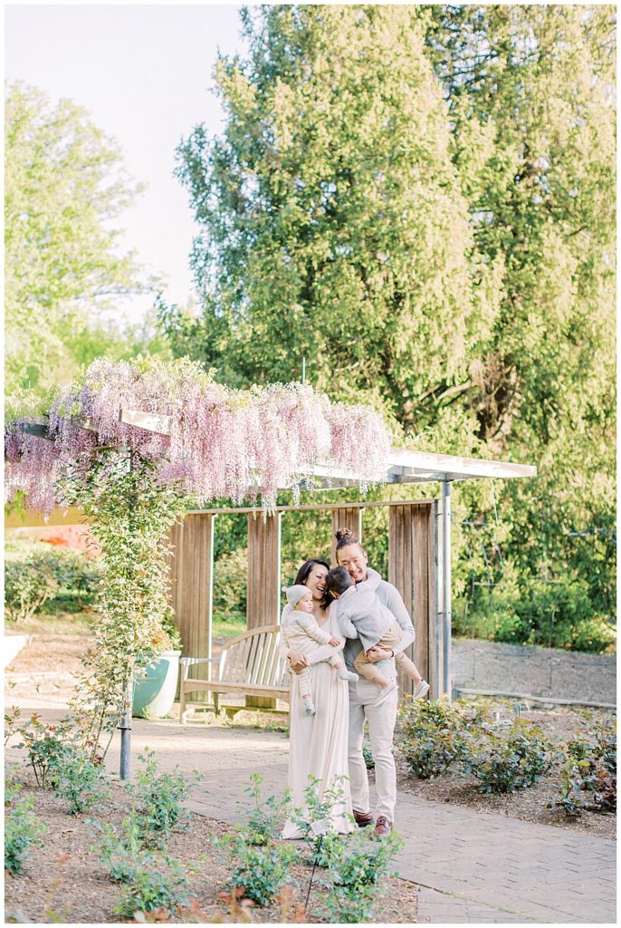 Family Cuddles Together Under The Purple Wisteria At Brookside Gardens