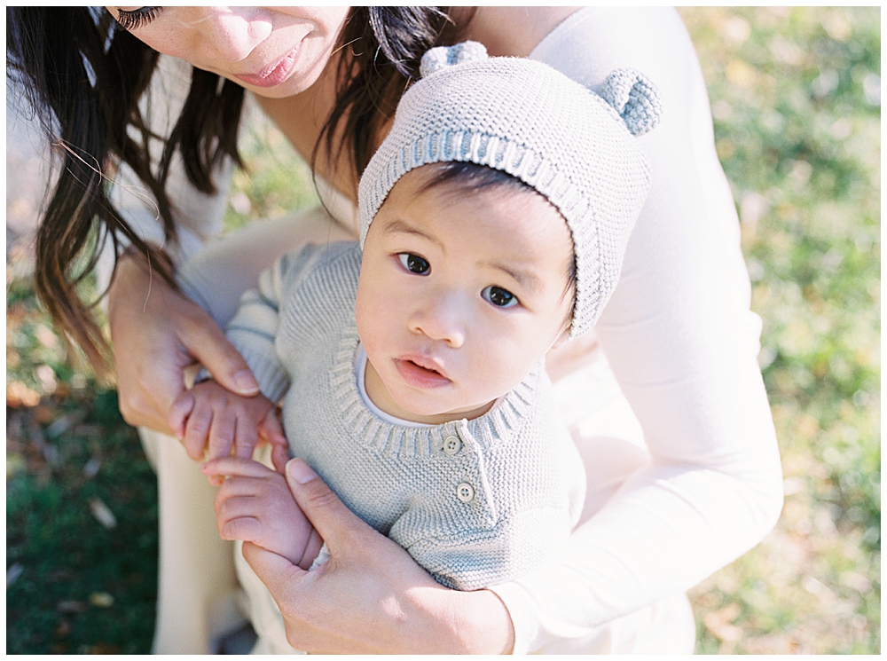 Little Boy Looks Up While His Mother Holds Him