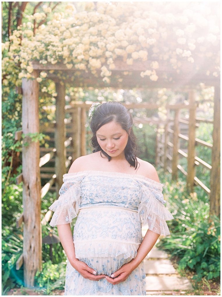 Expecting Mother Looks Down At Her Belly During A Dc Maternity Session At Tudor Place