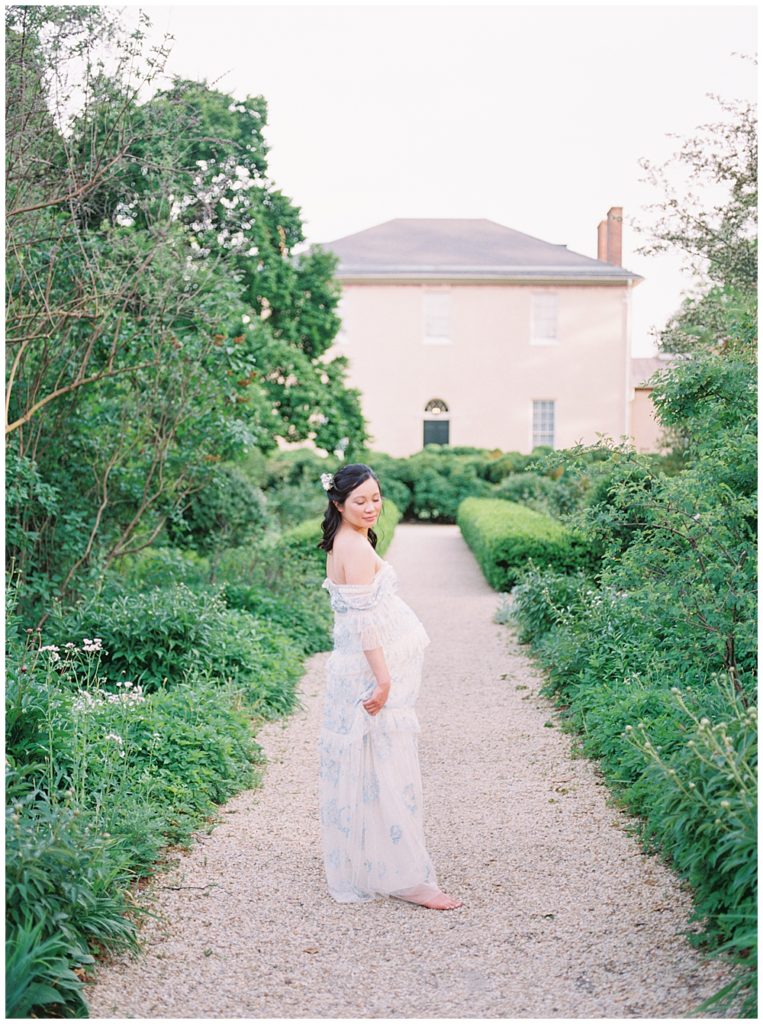 Woman Walks Along Path At Tudor Place During Maternity Session