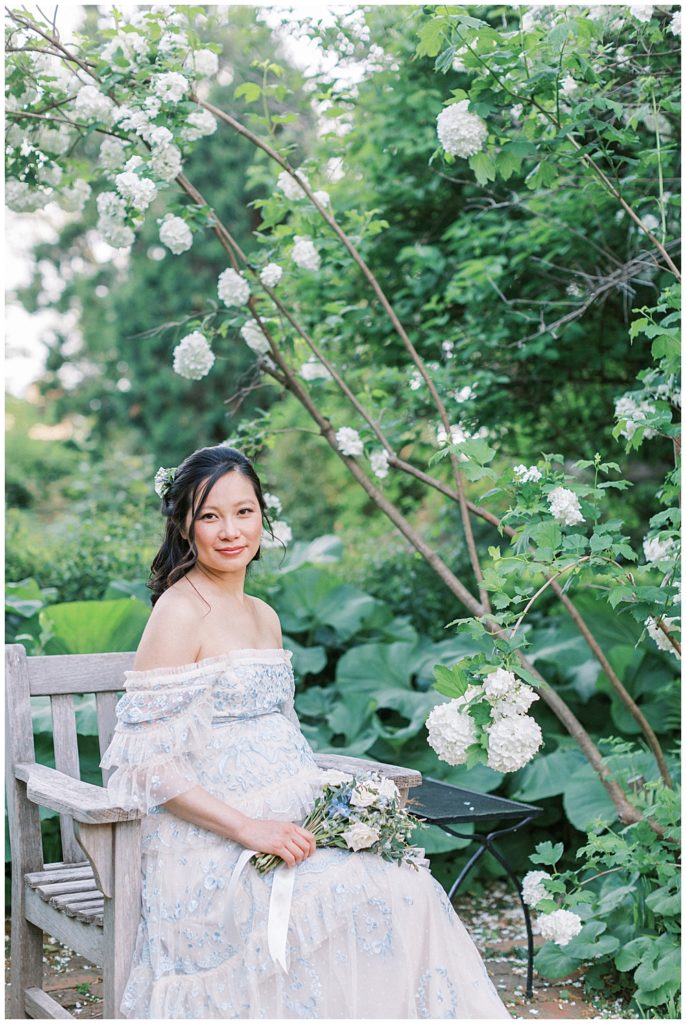 Pregnant Mother Sits On A Bench By Flowers At Tudor Place In Dc