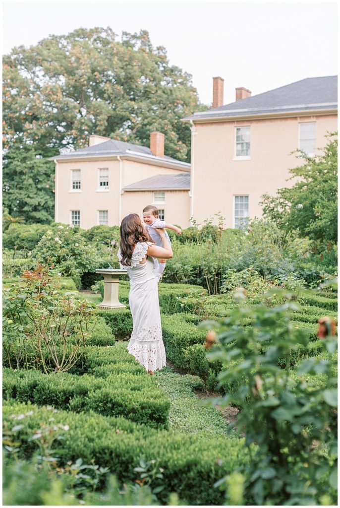 Mother Holds Up Her Baby Boy In The Gardens At Tudor Place In Washington Dc