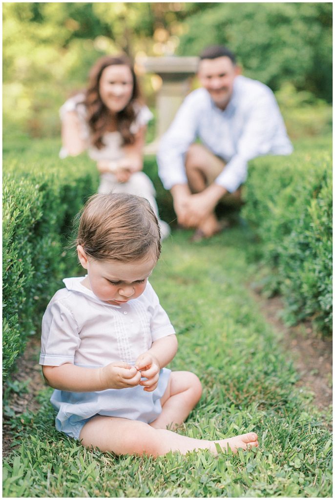 Parents Look Adoringly At Their One Year Old Son In The Gardens Of Tudor Place