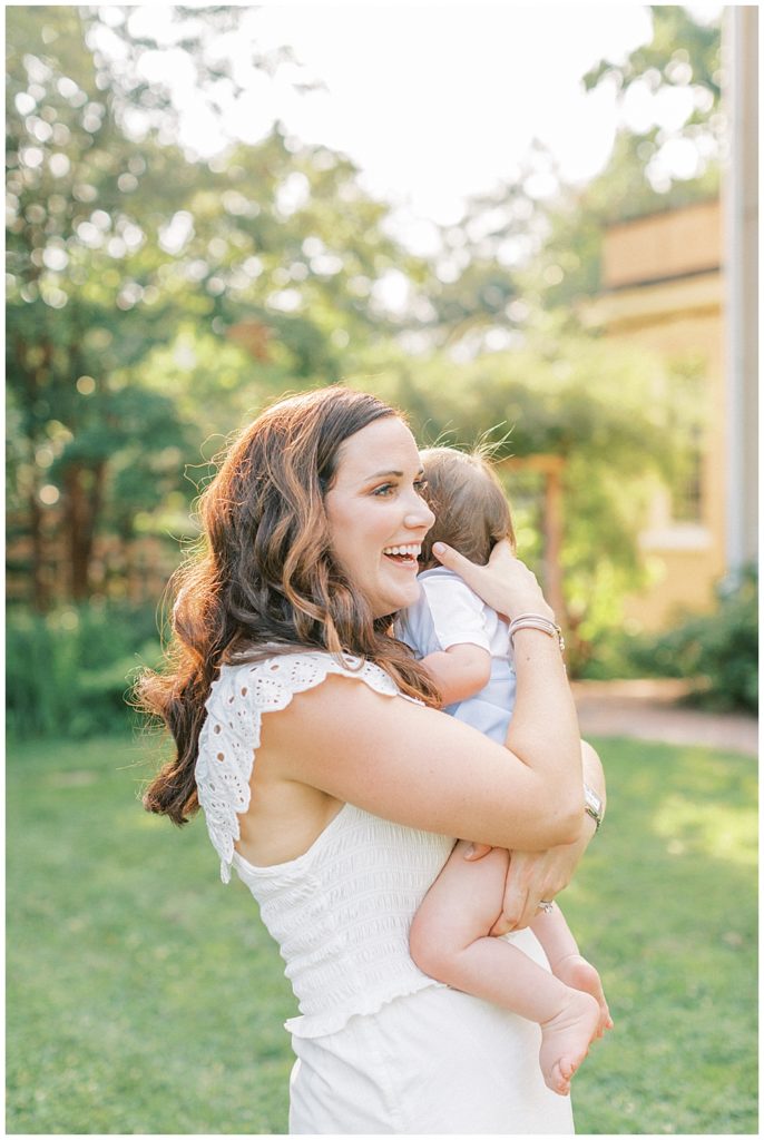 Mother Laughs While Holding Her One Year Old Boy