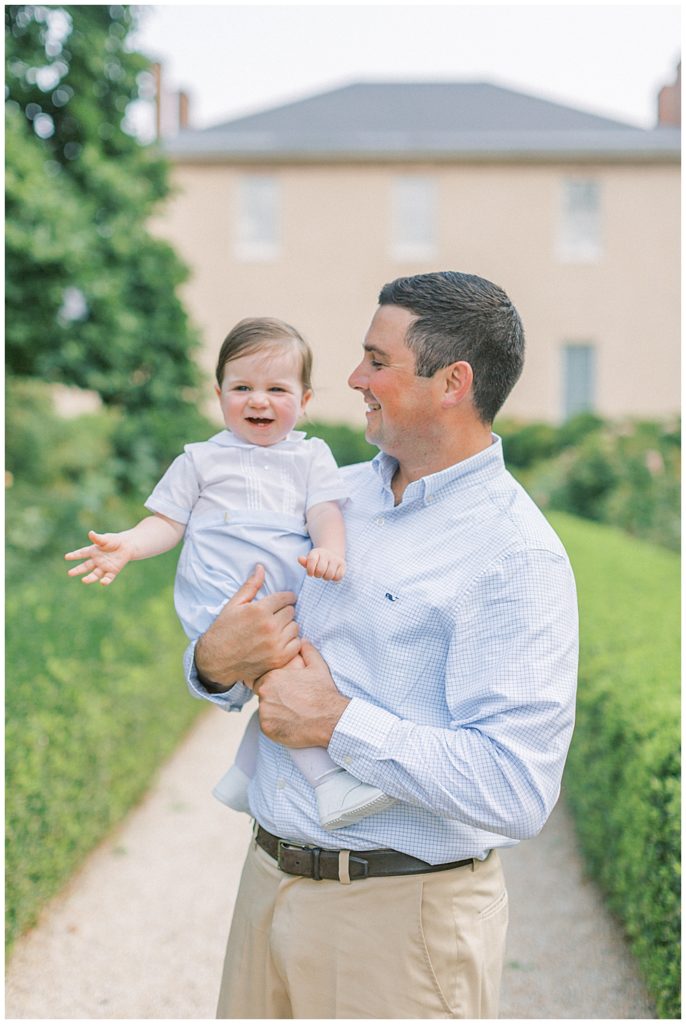 Dad Holds Smiling One Year Old Boy