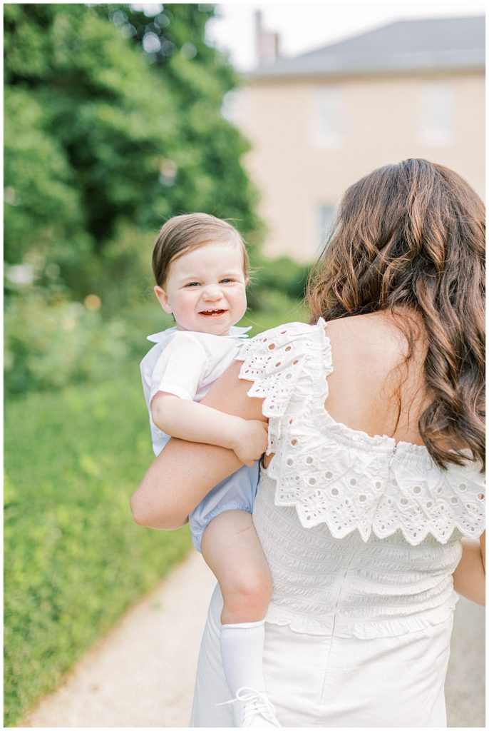 Mother Holds Her Son As He Smiles At The Camera