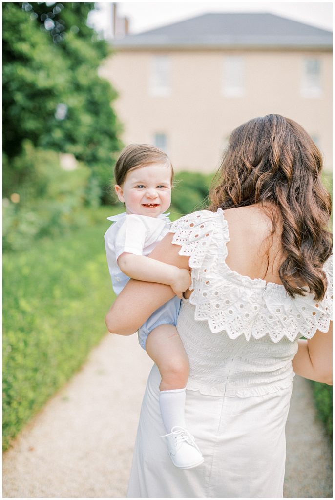 Mother Turns Around While Her One Year Old Boy Looks At The Camera