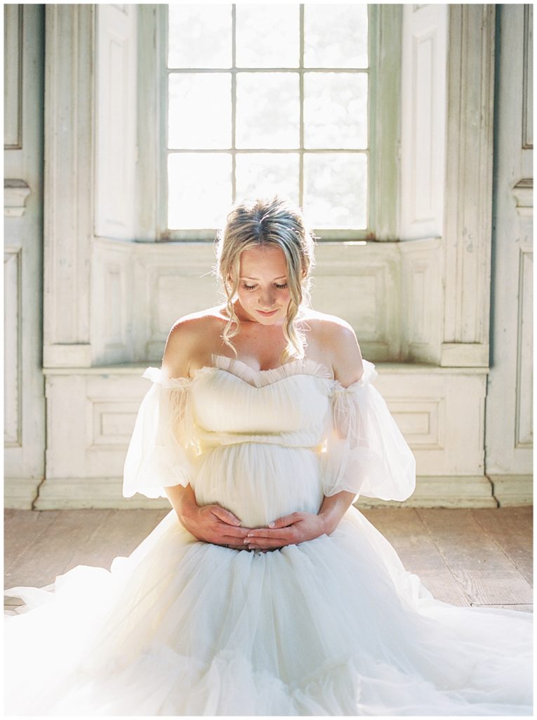 Dc Maternity Photographer | Pregnant Woman Kneels In Front Of A Window