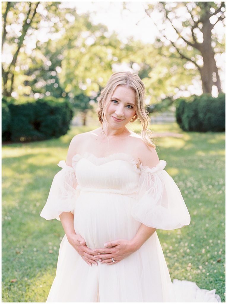 Pregnant Mother Stands With Hands Below Her Belly During Her Maternity Session At Salubria In Virginia