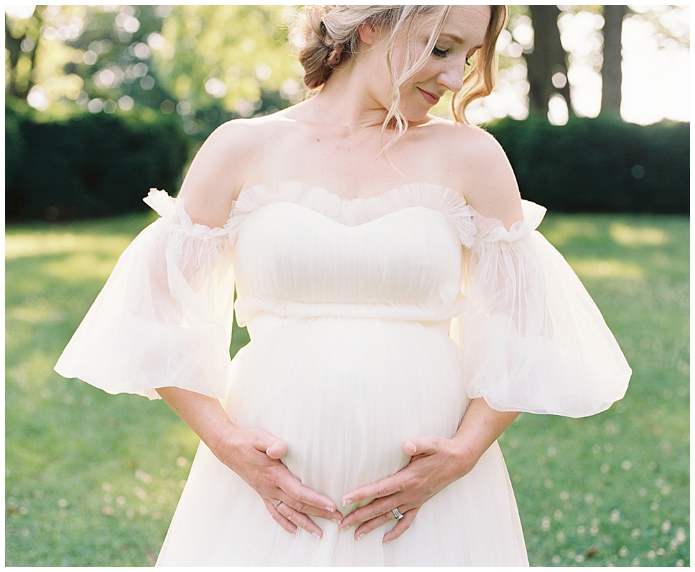 Pregnant Woman Stands Outside, Cradling Her Pregnant Belly During Her Dc Maternity Session