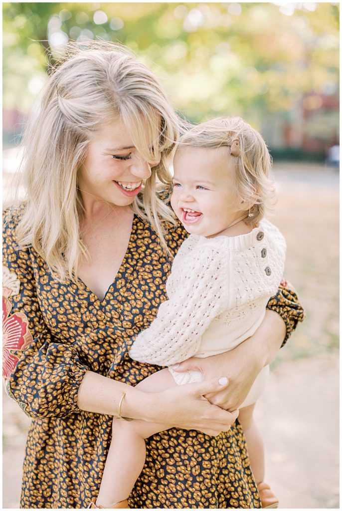 Mother holds her daughter and smiles