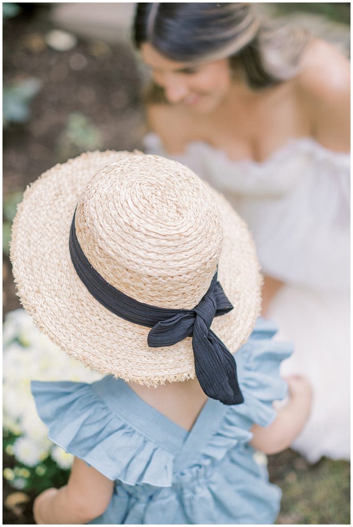 Toddler Girl And Her Mother Work In A Garden