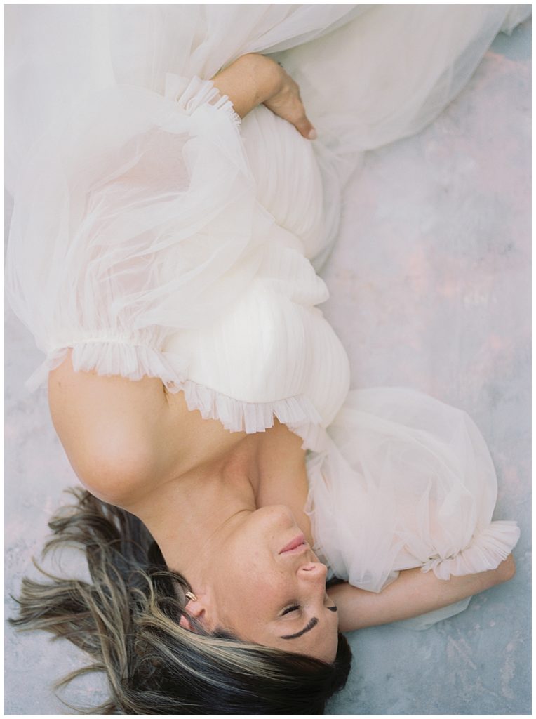 Pregnant Mother Lays Down With A Hand On Her Belly During Her Dc Studio Maternity Session