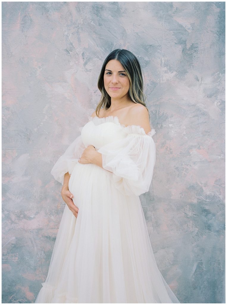 Pregnant Mother Stand With Hands On Her Belly During Her Studio Session In Washington Dc