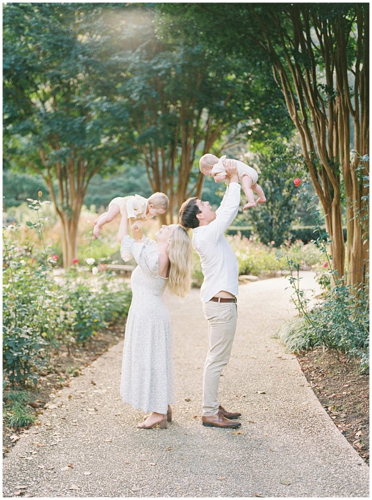 Parents Hold Up Their Twin Babies In The Air