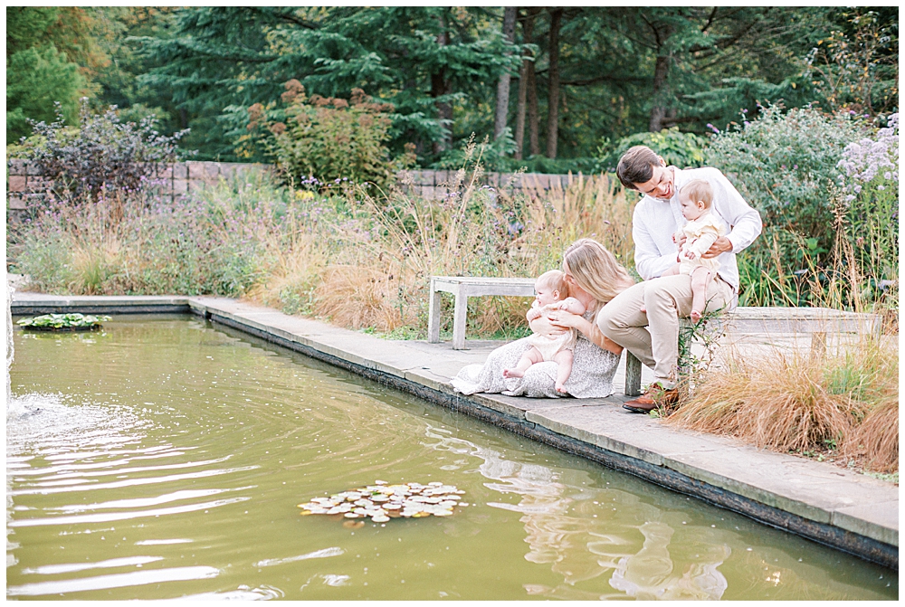 Family Sits On The Edge Of A Pond At Brookside Gardens