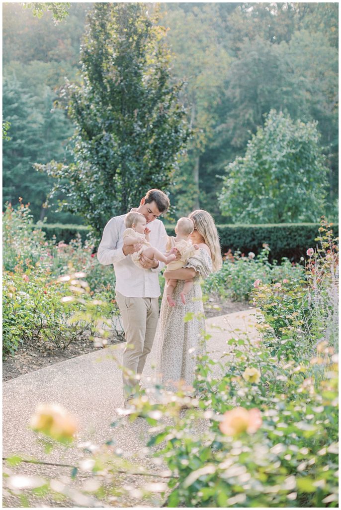 Parents hold and interact with their twin baby girls in Brookside Gardens