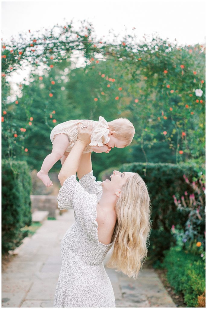 Mother Holding Her Baby Up In The Air At Brookside Gardens In Maryland