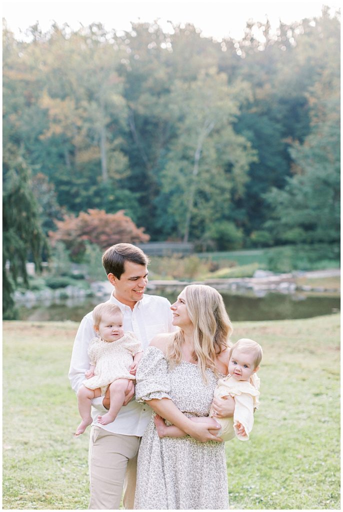 Mother And Father Look At Each Other While Holding Their Twin Babies